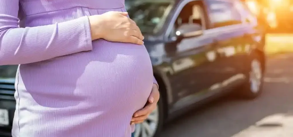 Gestante ao lado de um carro, ilustrando a dúvida "grávida pode dirigir até quando"