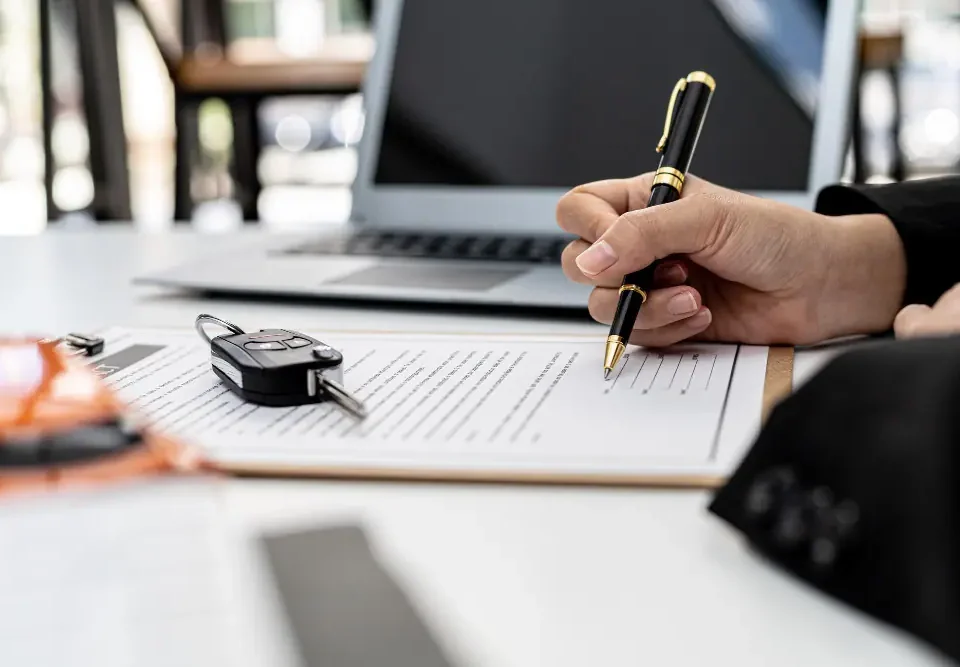 Assinatura de contrato de leasing de veículos com chave do carro sobre o documento