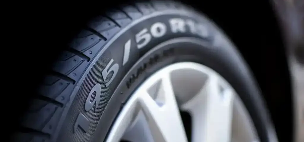 Imagem em close de um pneu automotivo destacando a numeração dos pneus gravada na lateral