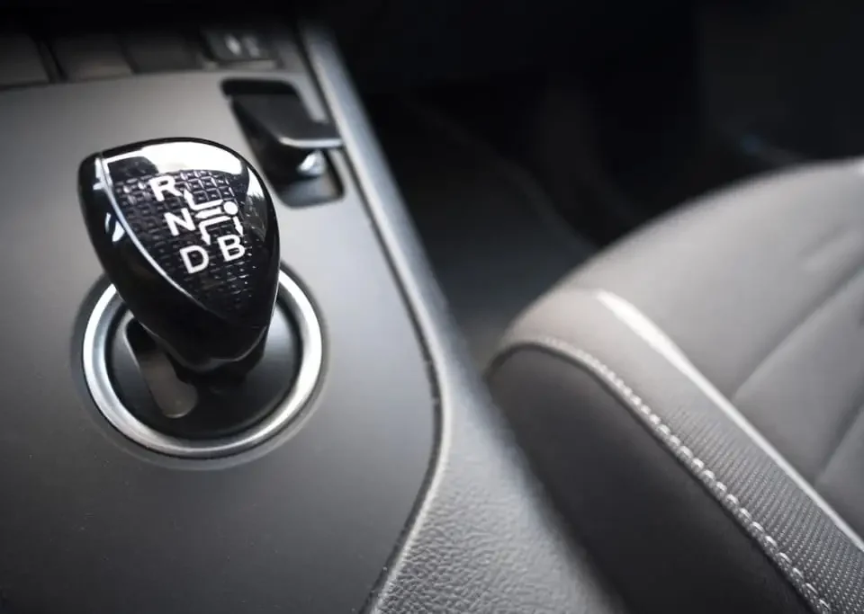 Alavanca do câmbio CVT em close-up no console do carro, destacando o seletor e acabamento do interior do veículo para referência técnica.