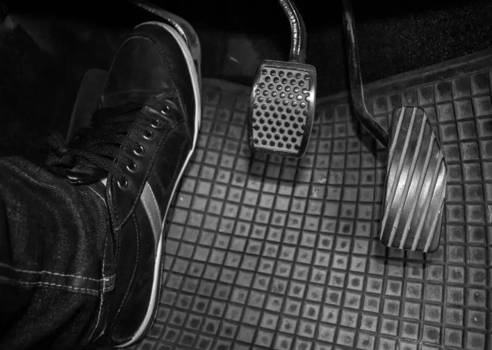 Carro com embreagem dura, mostrando pedal de embreagem pesado e dificuldade no acionamento ao dirigir.