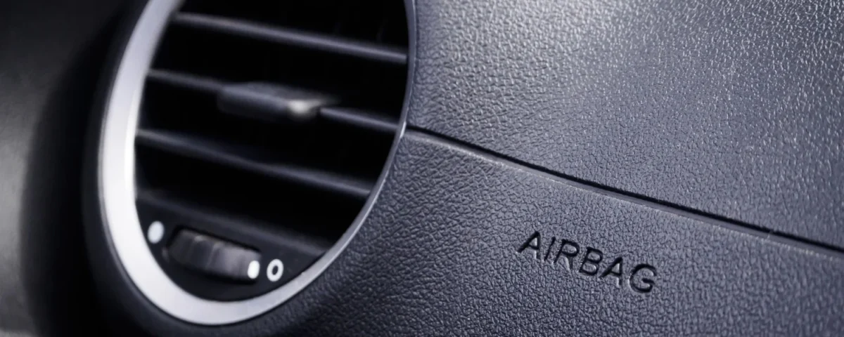 Detalhe do painel de carro com inscrição airbag e saída de ventilação