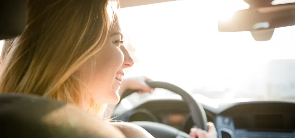 Mulher dirigindo carro representando aquisição de veículo por consórcio