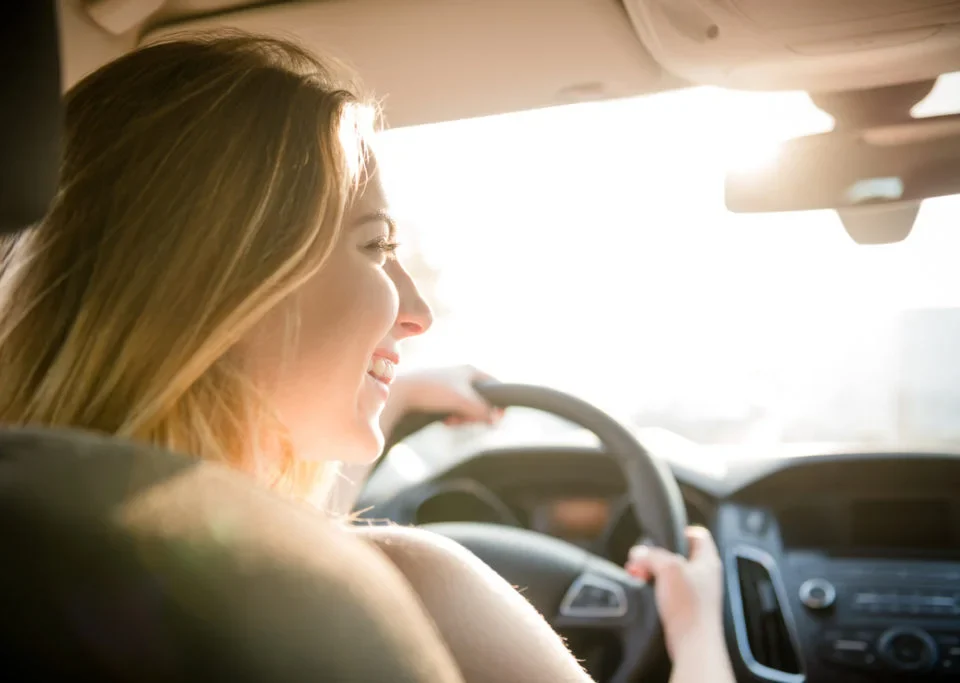 Mulher dirigindo carro representando aquisição de veículo por consórcio