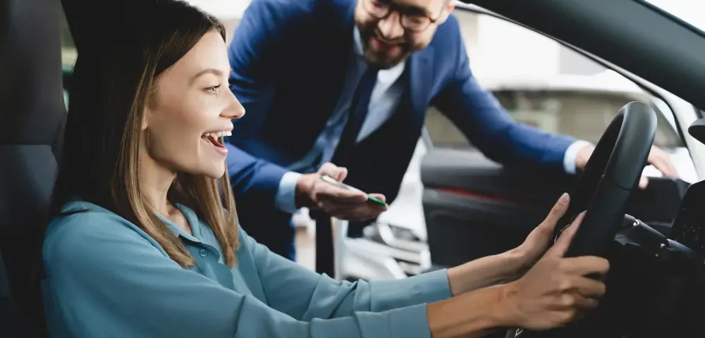 Vendedor explicando detalhes do veículo ao casal durante o test drive