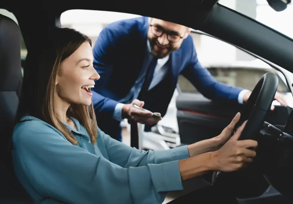 Vendedor explicando detalhes do veículo ao casal durante o test drive